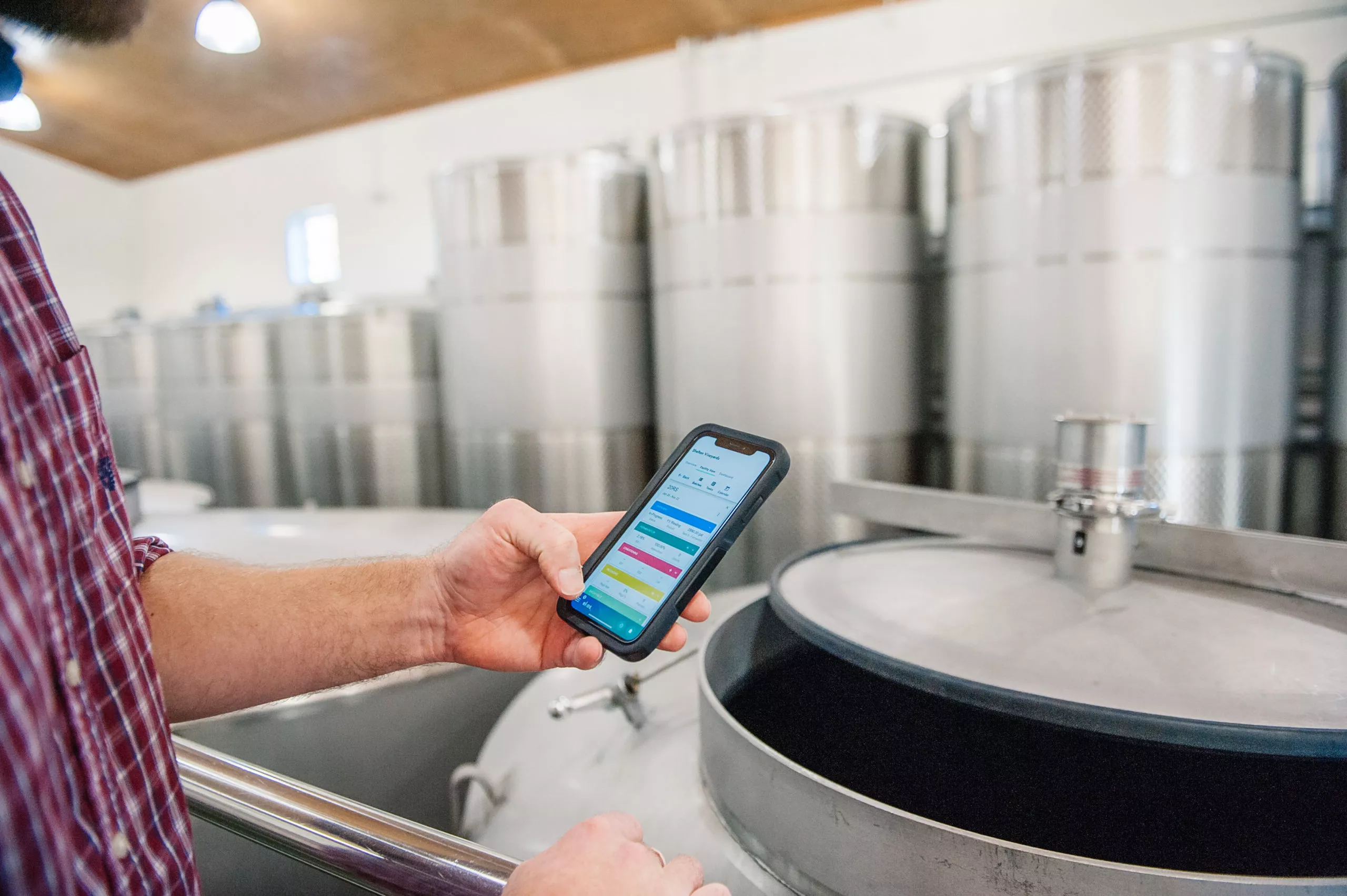 Winemaker using winery software in wine production area